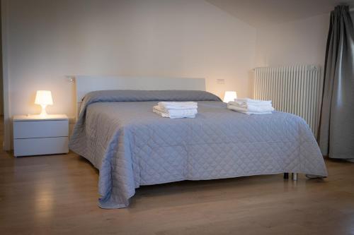 a bedroom with a bed with towels on it at Scalino 66 Suite del Teatro in Cesena