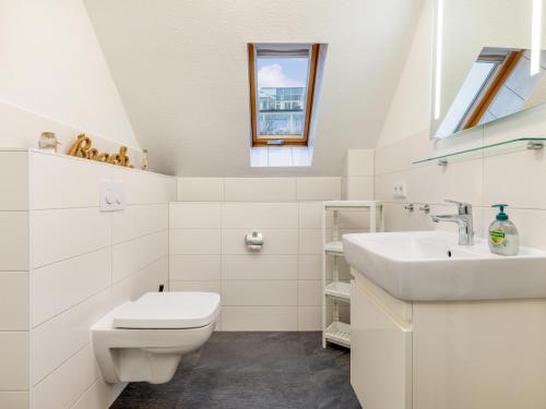 biała łazienka z umywalką i toaletą w obiekcie Ferienwohnung Meeresbrise in der Residenz Clara Sophia w mieście Binz