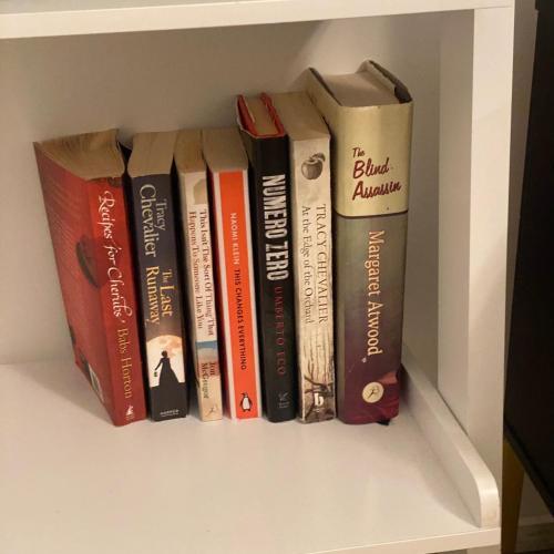 a group of books sitting on a shelf at Peterborough City Center Near Healthcare Center One Bed apartment With Free Private Parking Contractors Locum Staff welcome in Peterborough