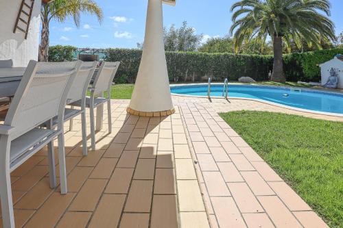 a group of chairs and a table next to a pool at 2 Vale de Ursa - Swimming Pool - WIFI - BY BEDZY in Guia