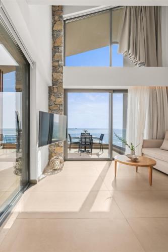 a living room with a view of the ocean at Evelmare Beachfront Apartments in Koutsourás