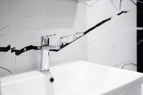a bathroom sink with a faucet on top of it at Stylish Cozy Apartment, Near Chisinau Center in Chişinău