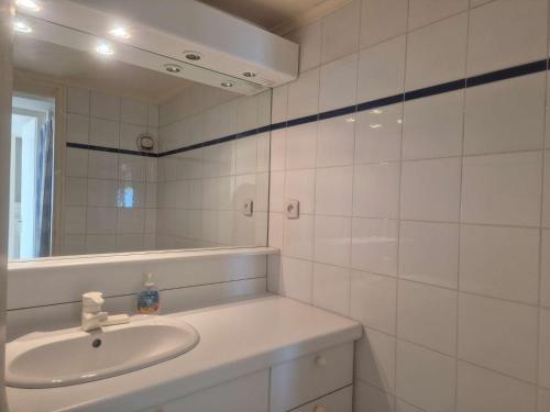 une salle de bain blanche avec un lavabo et un miroir dans l'établissement Appartement 3 pièces - Vue sur port - CAP D 'AGDE CT345-029, au Cap d'Agde