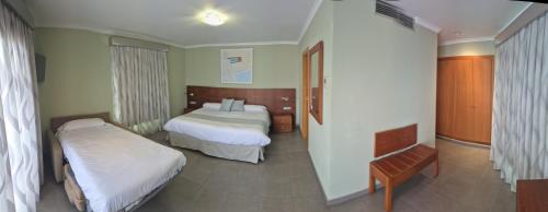 a hotel room with two beds and a table at Nou Avenida in Gata de Gorgos