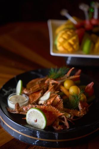 a black plate of food with seafood on a table at Kandahena Mansion in Akuressa