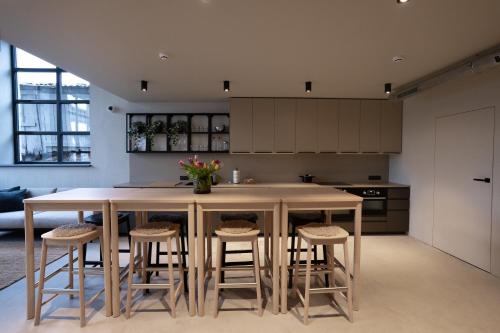 a kitchen with a large island with stools at citywave Vilnius in Vilnius
