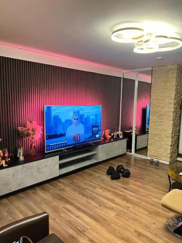 a living room with a large flat screen tv at Uxbridge Suite in Uxbridge