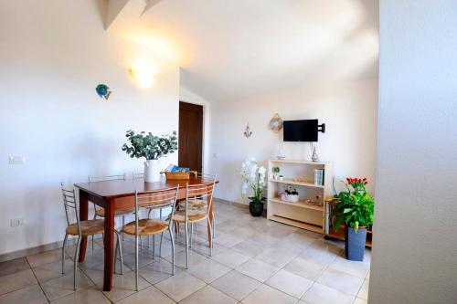 een eetkamer met een tafel, stoelen en een tv bij Suite Torrigiani in Cala Gonone
