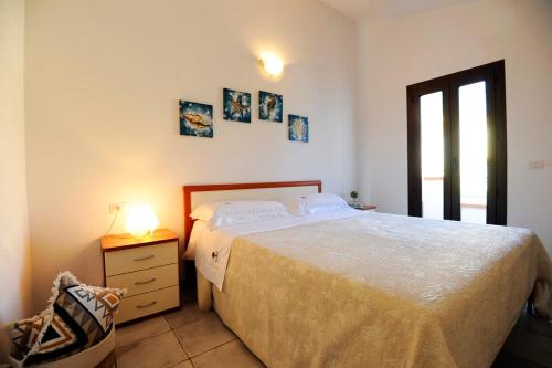 een slaapkamer met een bed en een lamp op een nachtkastje bij Suite Torrigiani in Cala Gonone
