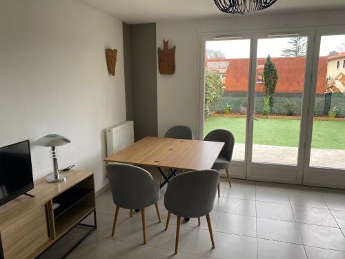 a dining room with a wooden table and chairs at maison sur le bassin d'Arcachon in Le Teich