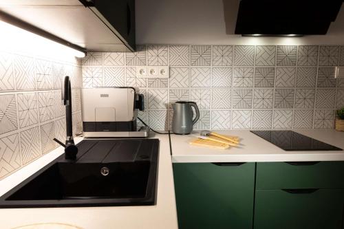 a kitchen with a sink and a coffee maker at Henry Domki - prywatna sauna i jacuzzi in Żywiec