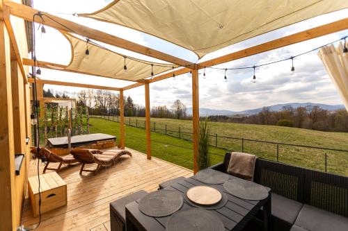 a patio with a table and a view of a field at Henry Domki - prywatna sauna i jacuzzi in Żywiec
