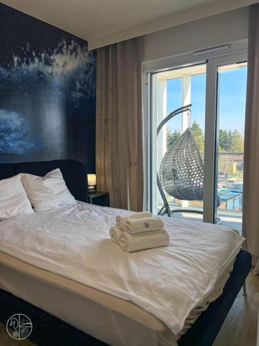 a bedroom with a bed with two towels on it at Apartament na wydmie - Perłowa Przystań in Sianozety