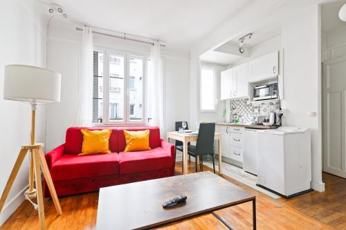 un salon avec un canapé rouge et une table dans l'établissement Heart of Paris - Studio - 2P - Invalides Free Netflix, à Paris