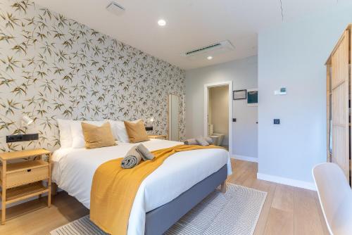 a bedroom with a large bed with a yellow blanket at Las Dunas de Santa Catalina Boutique House in Las Palmas de Gran Canaria