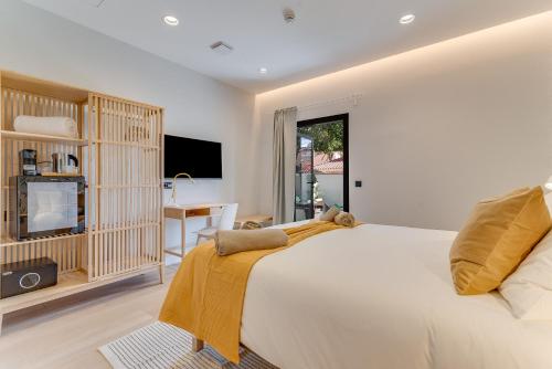 a bedroom with a large bed and a television at Las Dunas de Santa Catalina Boutique House in Las Palmas de Gran Canaria
