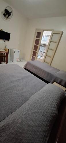a bedroom with a large bed and a window at Hotel Plaza Olido in Sao Paulo
