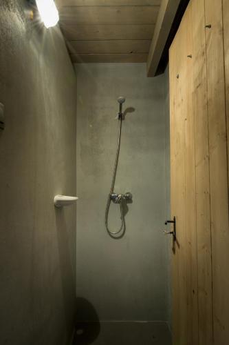 a bathroom with a shower in the wall at Csernus Doki bor-grillterasza és bungallói in Eger