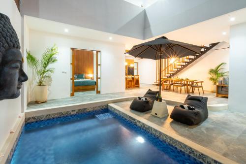 a villa with a swimming pool and a living room at Villa Sunset Waters in Legian