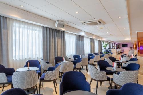 a waiting room with chairs and tables and windows at Hotel Avenida in Benidorm