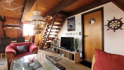 a living room with a television and a staircase at Ferienhaus Ankerplatz Twielenfleth im Feriendorf Altes Land in Hollern-Twielenfleth