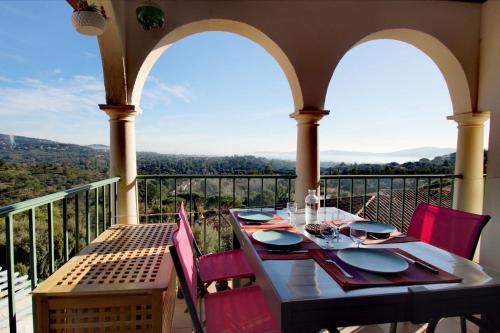 une table et des chaises sur un balcon avec vue dans l'établissement Les Restanques vue mer violettes 1167, à Grimaud