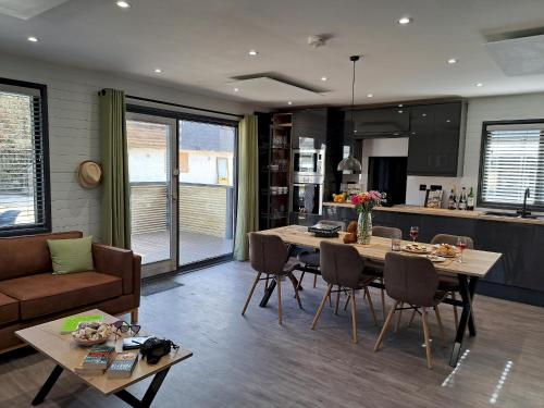 a kitchen and living room with a table and a couch at Cardinham Lodge 3 bedroom - max 6 occ - VP4 in Looe