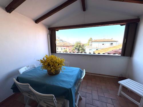 a room with a table with a vase of flowers on it at Attic Lagoon View in Lido