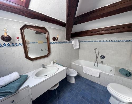 a bathroom with a sink and a toilet and a mirror at Attic Lagoon View in Lido
