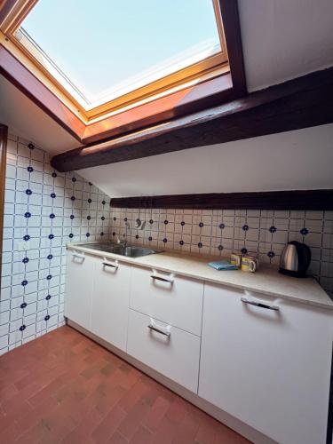 a kitchen with white cabinets and a skylight at Attic Lagoon View in Lido