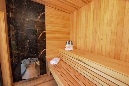 a wooden sauna with two towels on a wooden bench at Nadmorski Spokój, domki i sauna in Lubiatowo