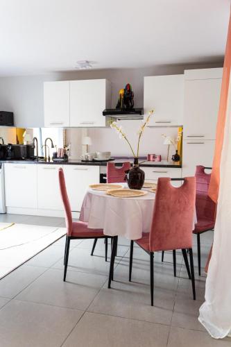 une cuisine avec une table et des chaises rouges et une cuisine avec des placards blancs dans l'établissement Apartment in Cannes, à Cannes