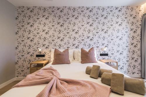 a bedroom with a large bed with a floral wallpaper at Las Dunas de Santa Catalina Boutique House in Las Palmas de Gran Canaria