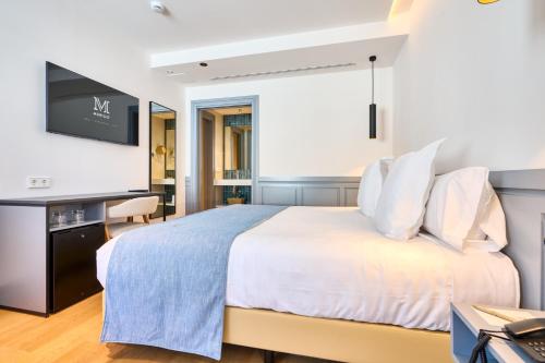 a hotel room with a bed and a flat screen tv at Hotel Murillo Reinoso in Seville
