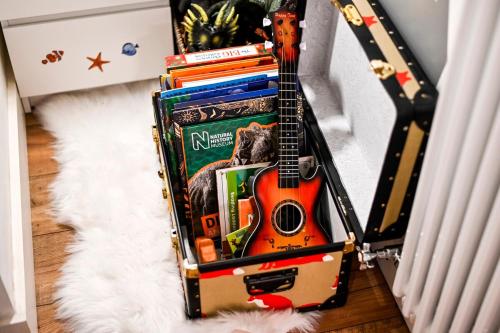 a suitcase full of books and a guitar at HotTub Spacious Garden house in London