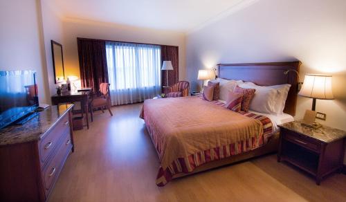a hotel room with a bed and a television at The Orchid Hotel Mumbai Vile Parle in Mumbai