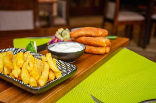 a table with a plate of french fries and dip at The Kyaka Hotel in Machakos