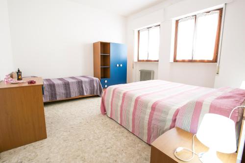sypialnia z 2 łóżkami i biurkiem oraz 2 oknami w obiekcie Le Palme 2 Pineto Vacanza w mieście Pineto