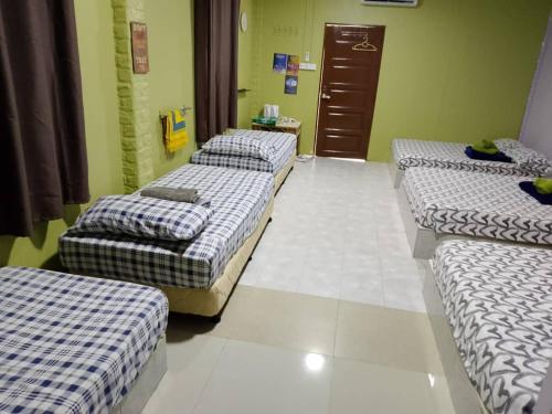 a room with three beds in a row in a room at kieara Redang Chalet in Kampong Pinang