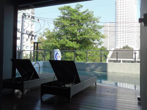 a balcony with two chairs and a swimming pool at Sea Crest by Jomtien in Jomtien Beach
