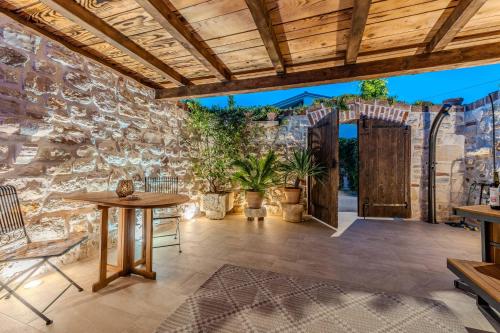 an outdoor patio with a wooden door and a stone wall at Roman style stone Villa Lux Solis in Nin