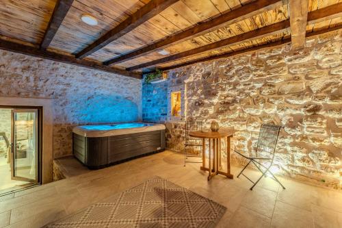 a room with a stone wall with a bed and a table at Roman style stone Villa Lux Solis in Nin