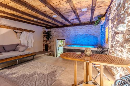 a room with a bed and a wooden table at Roman style stone Villa Lux Solis in Nin