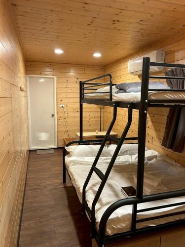 a room with two bunk beds in a cabin at B&B American Style cabin 5 minutes from the sea in Hengchun
