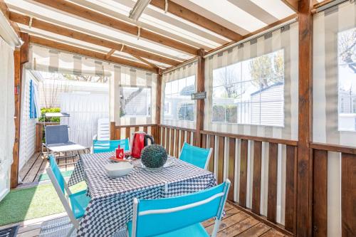 d'une terrasse couverte avec une table et des chaises bleues. dans l'établissement Mobilhome au calme - piscine, à La Parée Preneau