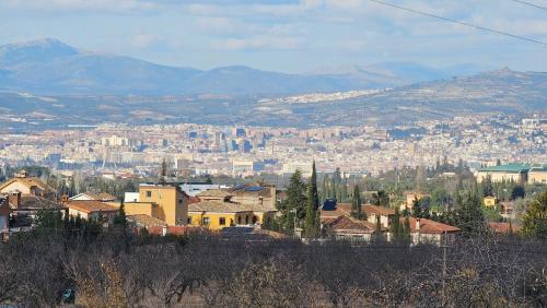 a view of a city with buildings and mountains at Apto-en el Bajo de la casa-estilo rústico en Dílar in Dílar