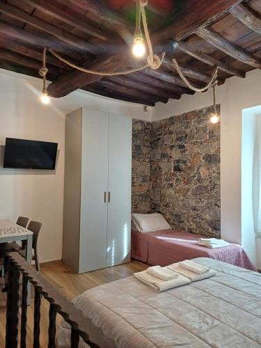 a bedroom with two beds in a room with a stone wall at Matt house in La Spezia