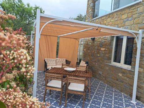 a patio with a wooden table and chairs under a pergola at Paomà Sorrento in Agropoli