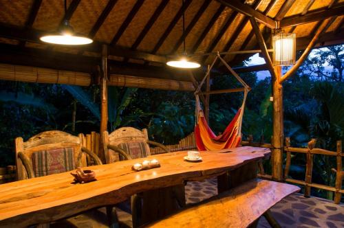 a wooden table in a room with a hammock at Temple Retreat Rumah Cantik in Banjar