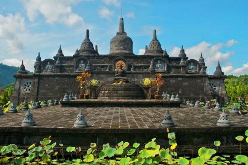 a building with a fountain in the middle of a garden at Temple Retreat Rumah Cantik in Banjar
